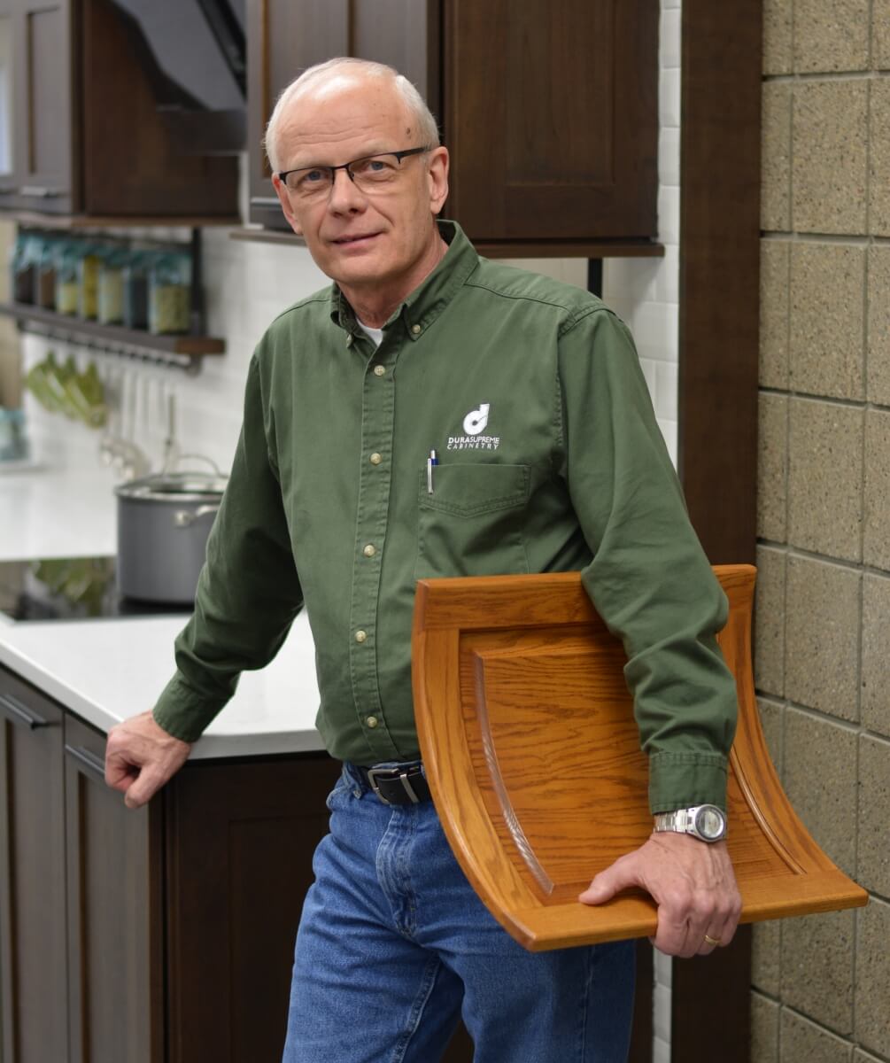 A long-term employee and product developer at Dura Supreme Cabinetry holds one of his legacies for the company, the curved cabinet door!
