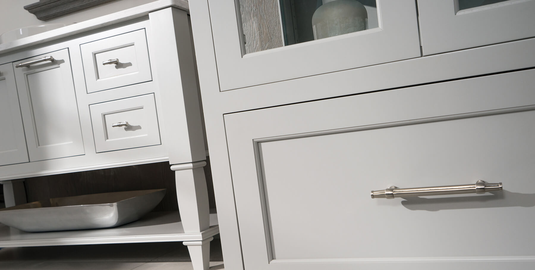 A close up of furniture styled bathroom furniture with a gray painted finish and transitional style from Dura Supreme Cabinetry.