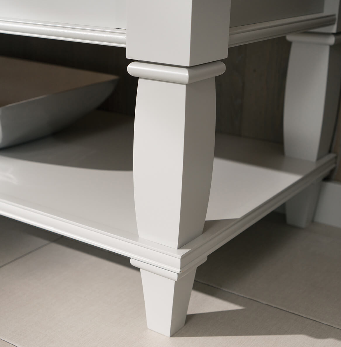 A close up of the Furniture Style vanity with a delicate, transitional styled turned post leg and floor shelf.