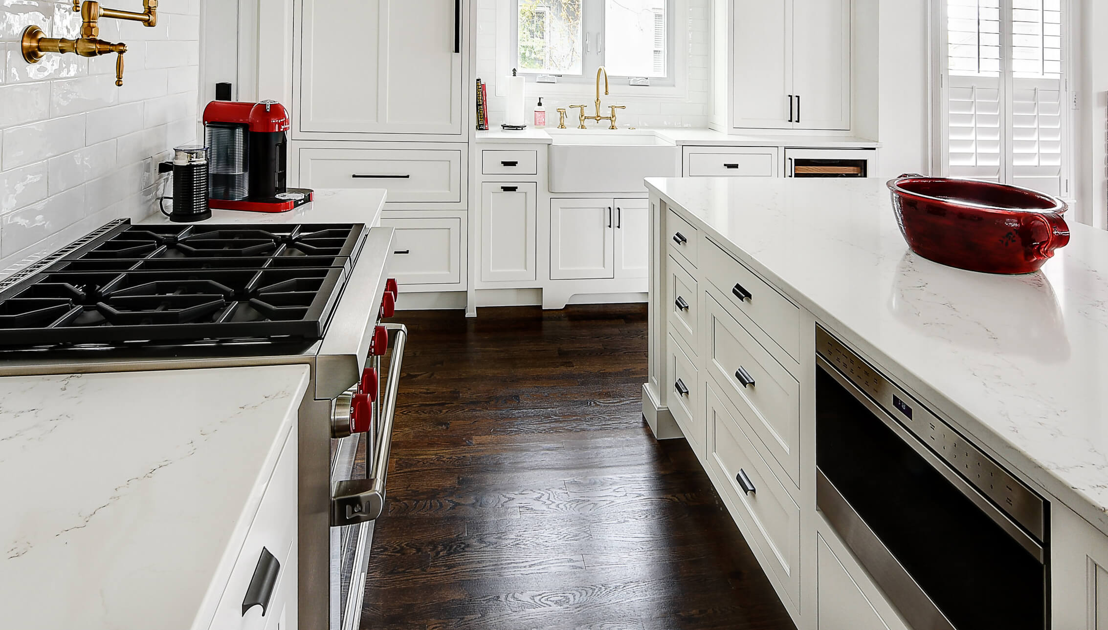 An all-white kitchen that mixes slab drawer fronts and 5-piece drawer fronts for a classic look using inset cabinet construction.