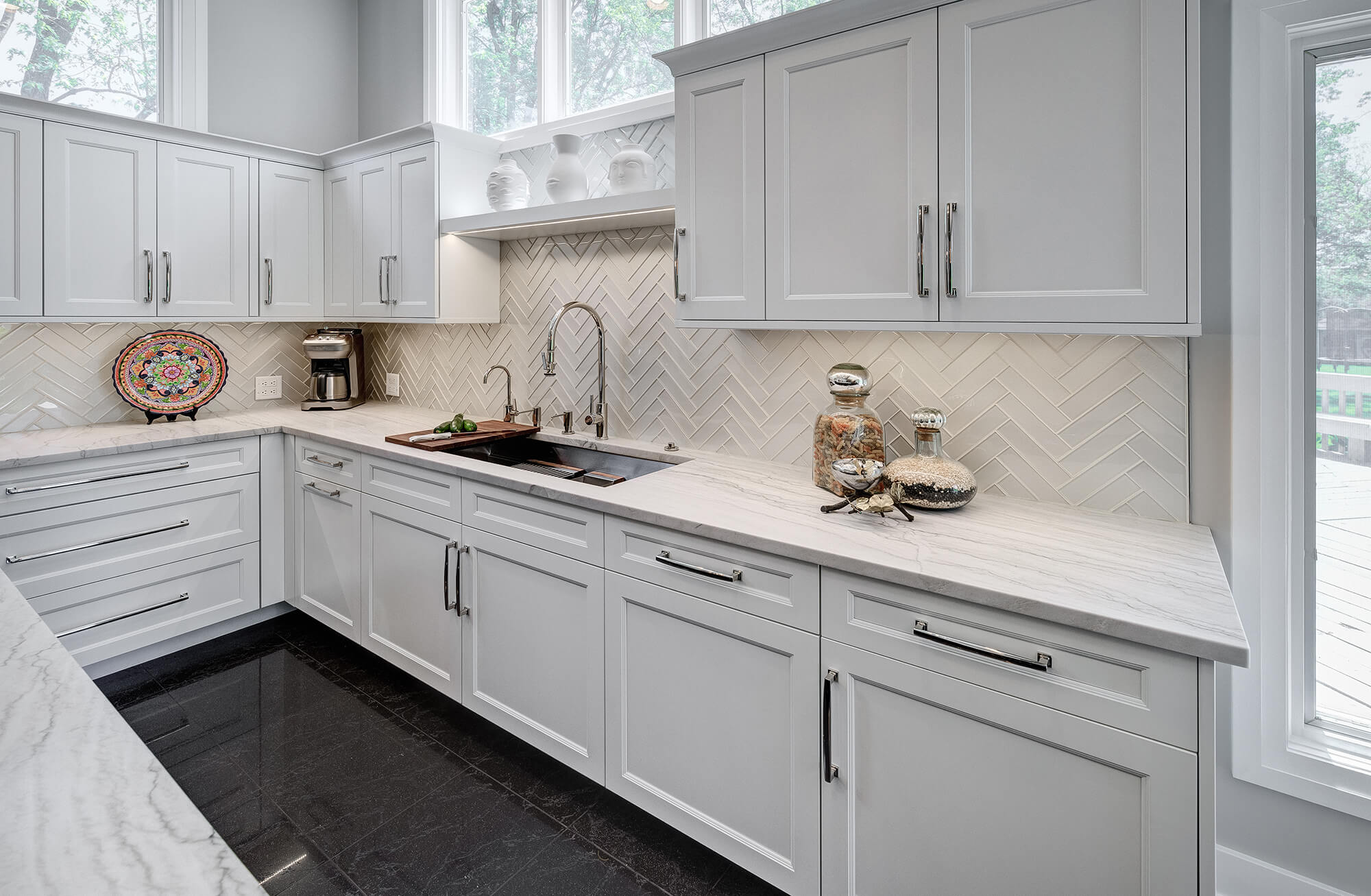 A wall of white cabinets with a hidden, panel ready dishwasher in a beautiful transitional kitchen design.