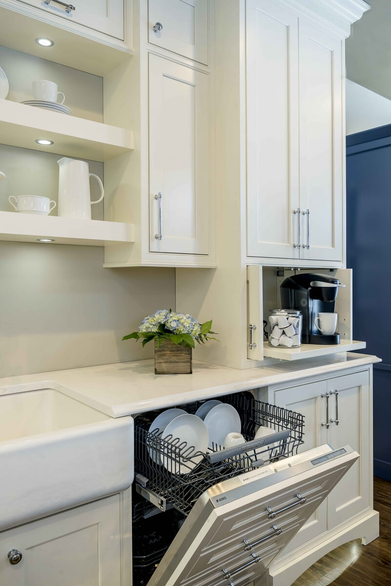 A dishwasher is hidden with a cabinet appliance panel that looks like a row of 4 stacked drawers. It's shown open in this image.