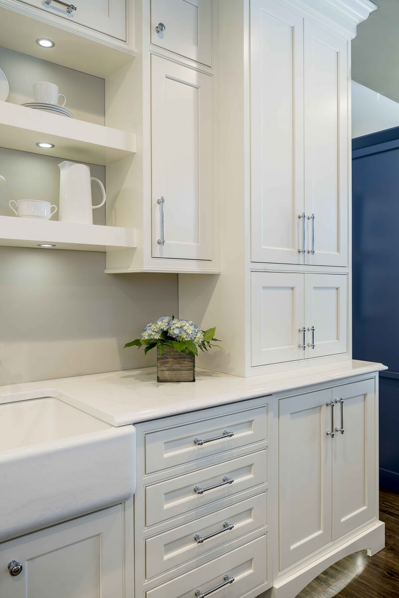 A dishwasher is hidden with a cabinet appliance panel that looks like a row of 4 stacked drawers. It's shown closed in this image.