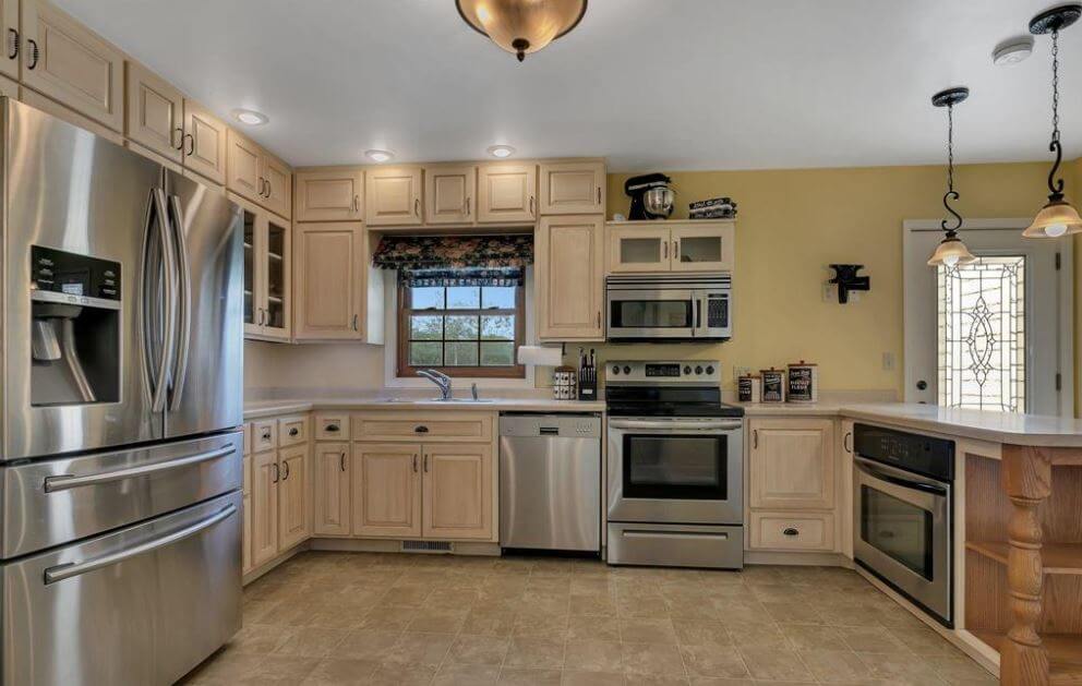 A kitchen design that is crowded with too many built-in stainless steel kitchen appliances. This design would work better with paneled kitchen appliances.