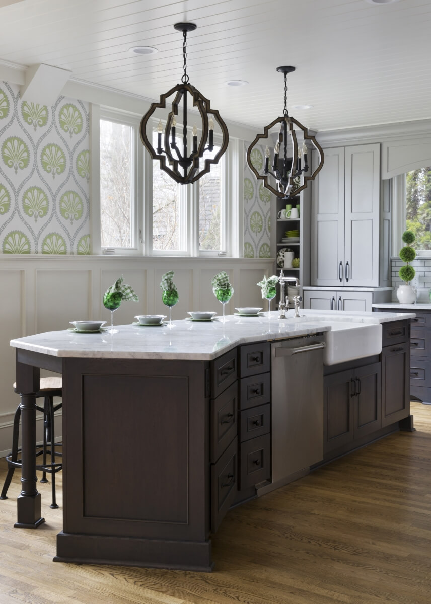 An angled kitchen island with gray stained inset cabinets.