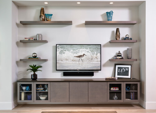 A light gray stained contemporary entertainment center with a collection of matching floating shelves in a modern living room design.