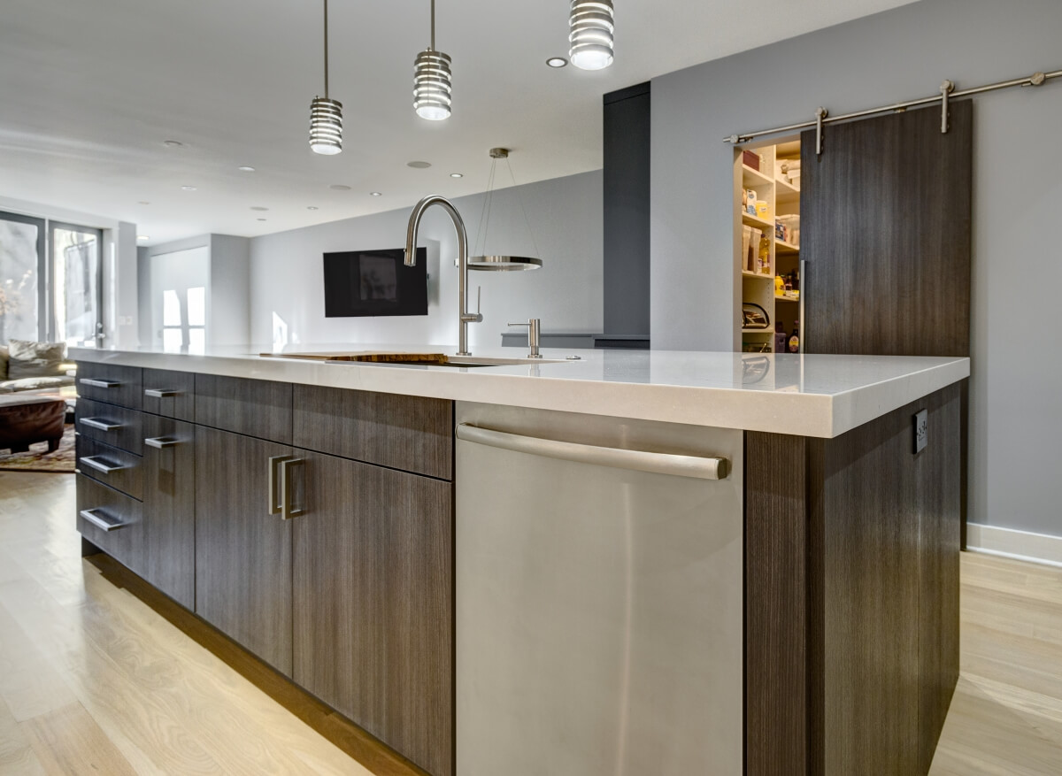 View of working side of the kitchen island and barn door entry to new walk-in pantry. Photography by Dennis Jourdan.