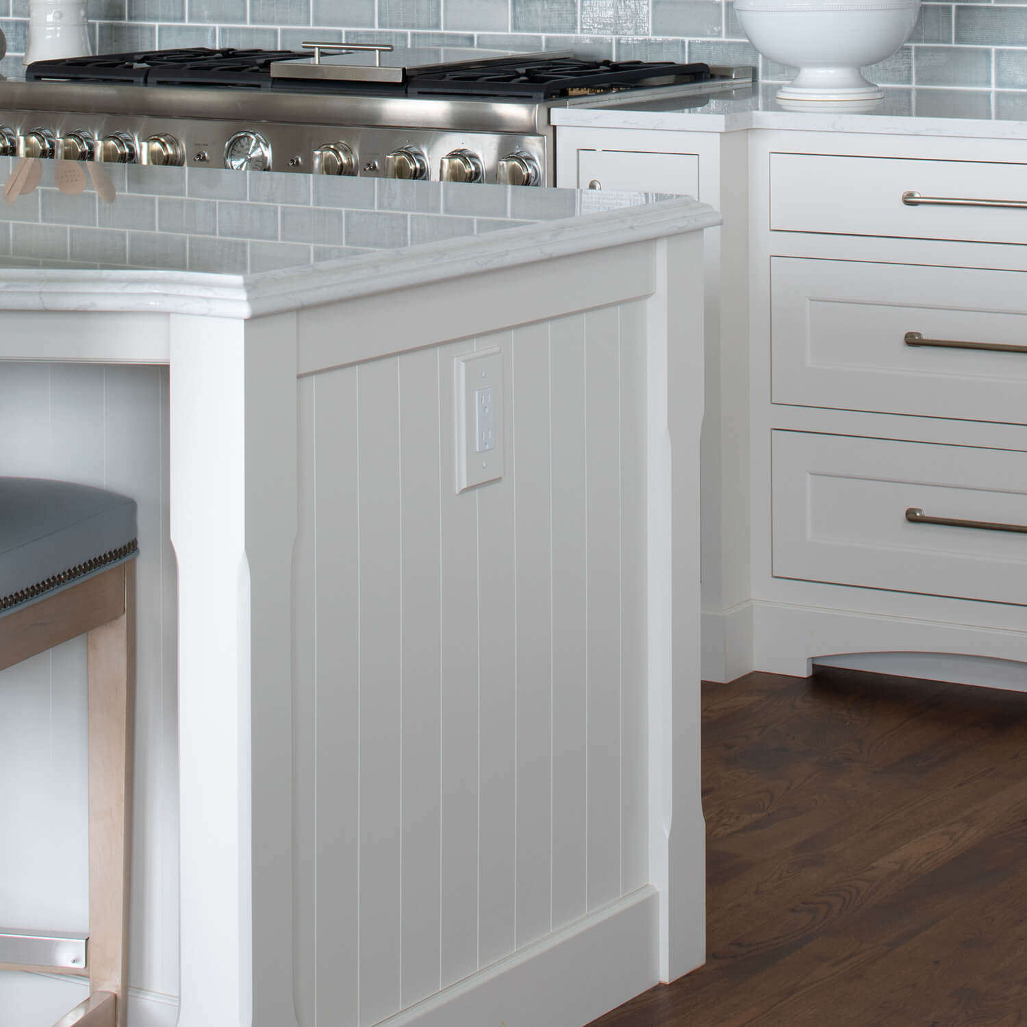 A coastal style kitchen island end cap with v-groove panel that looks like shiplap shown in a white paint color.