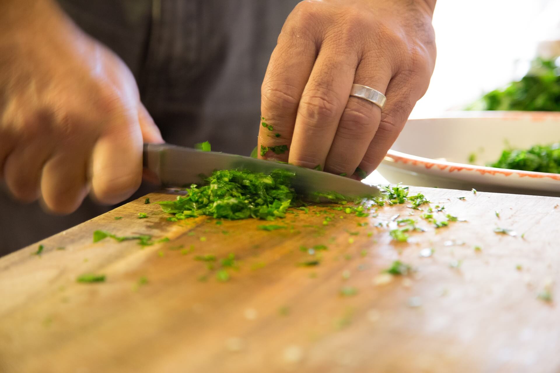 man in kitchen chopping and preparing food.