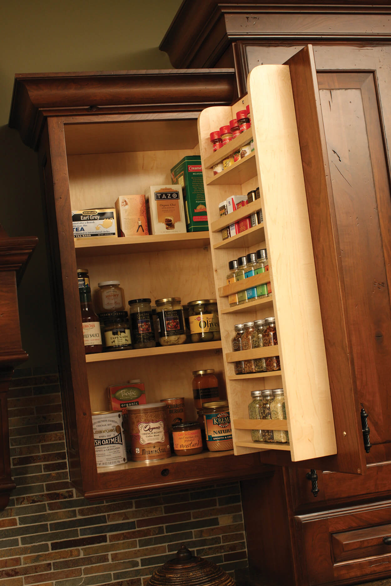 A traditional wall cabinet door spice rack from Dura Supreme Cabinetry stores row after row of spices.