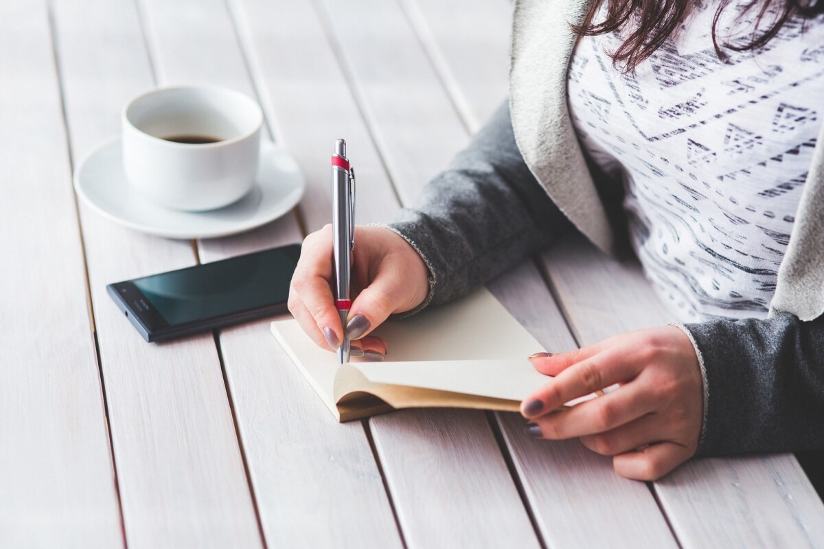 Woman making notes about her kitchen remodel plans and wish list.