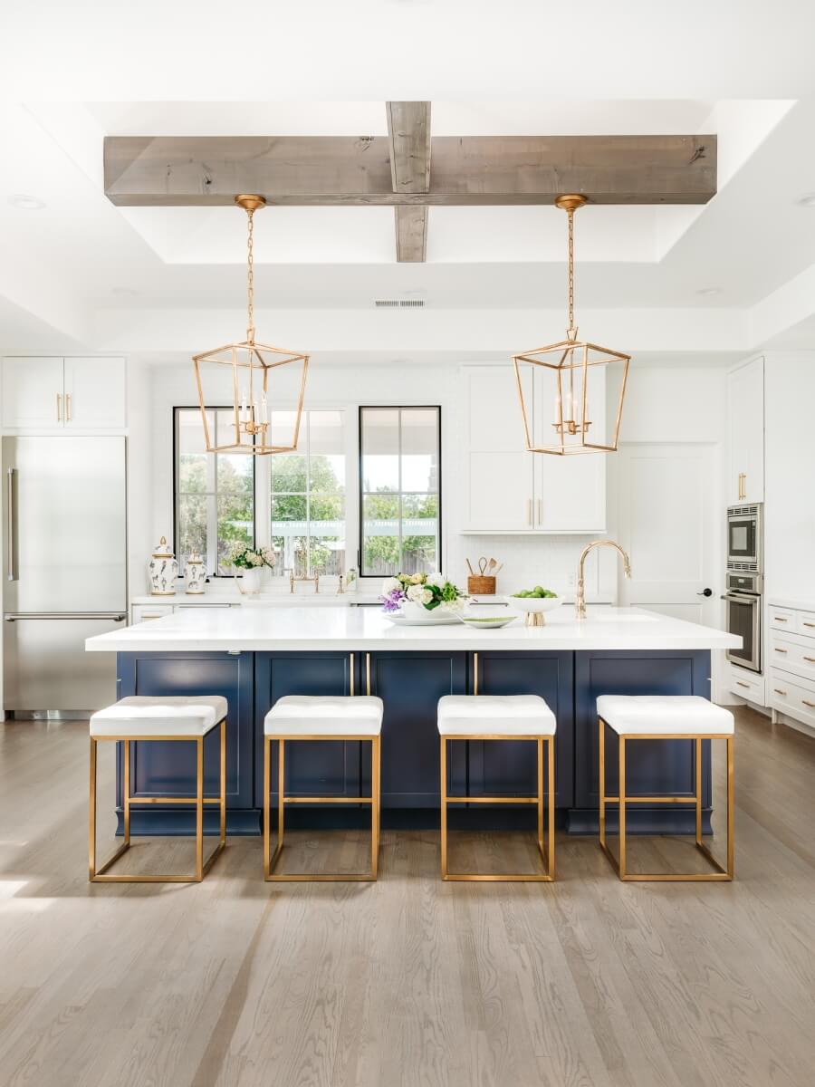 This kitchen island dramatically contrasts the white cabinetry and includes a clean-up center. Dura Supreme Cabinetry design by Helena Steele of Golden Gate Kitchens. Photo by Christopher Stark Photography.