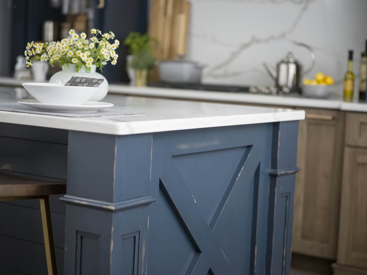 A furniture look kitchen island with an X patterned, modern farmhouse inspired end cap.
