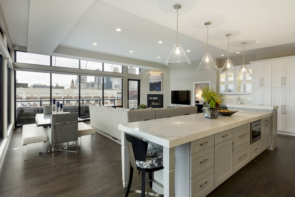 This kitchen island helps divide the kitchen space from the living space. Dura Supreme Cabinetry design by Ispiri Design Build Remodel.