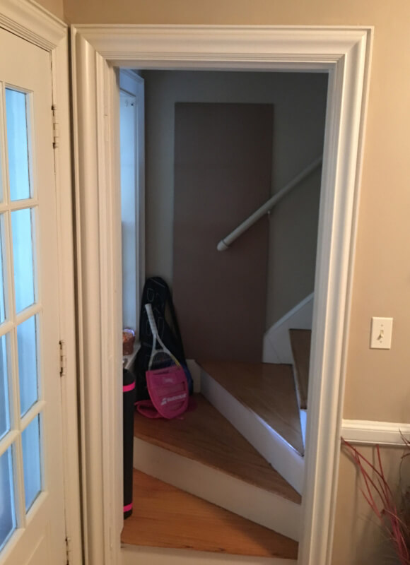 Before photo of the kitchen looking showing the staircase entryway.