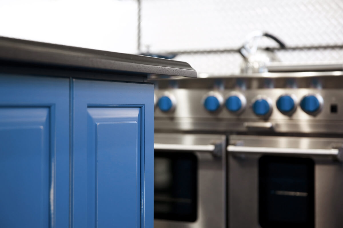 The kitchen island shown in a custom blue artisan finish by Dura Supreme Cabinetry.