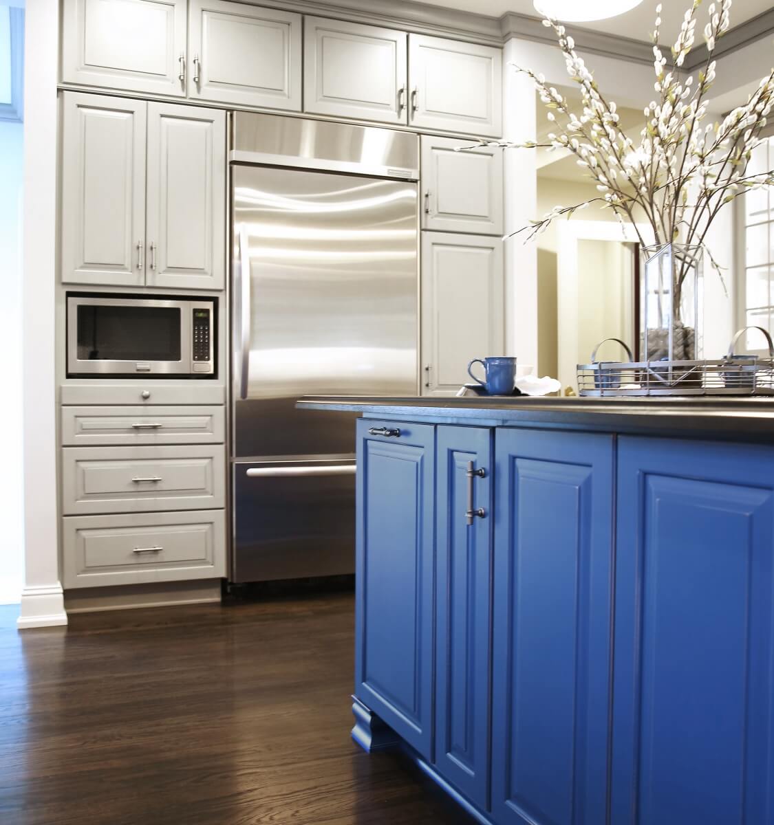 The kitchen island shown in a custom blue artisan finish by Dura Supreme Cabinetry.