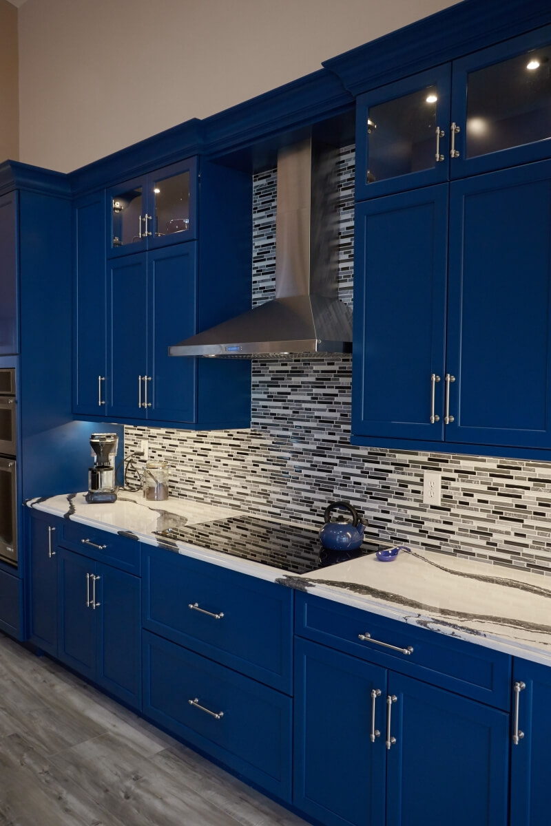 Decorative and task lighting was incorporated into this kitchen design to create a pop and highlight the dramatic backsplash tile and Cambria Quartz countertops.