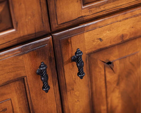 A Patina finish has an aged look where the corners of the cabinet doors have darkened corners and hand-detailing.