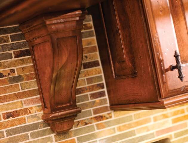 Mountain kitchen design style features large scale corbels and architectural elements like this large corbel on the wood hood.