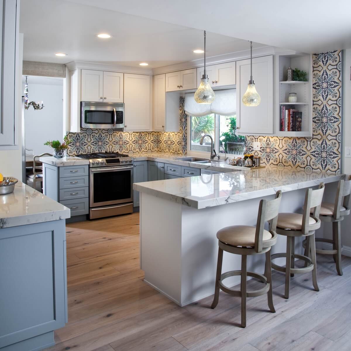 A colorful G-shaped kitchen design with white and gray cabinets.