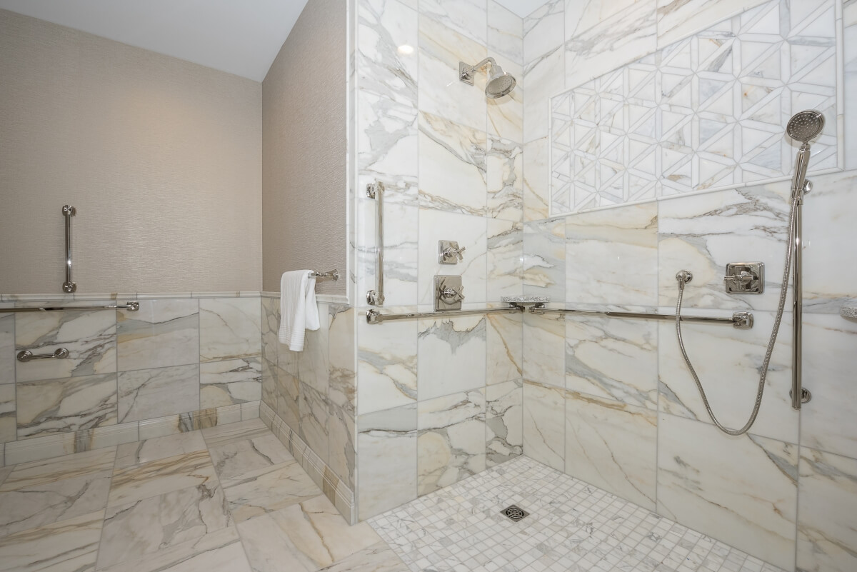 This ADA Compliant bathroom features safety grab bars throughout the space. Designed by Pinnacle Design, Saginaw, Michigan and photographed by Dan Denardo.