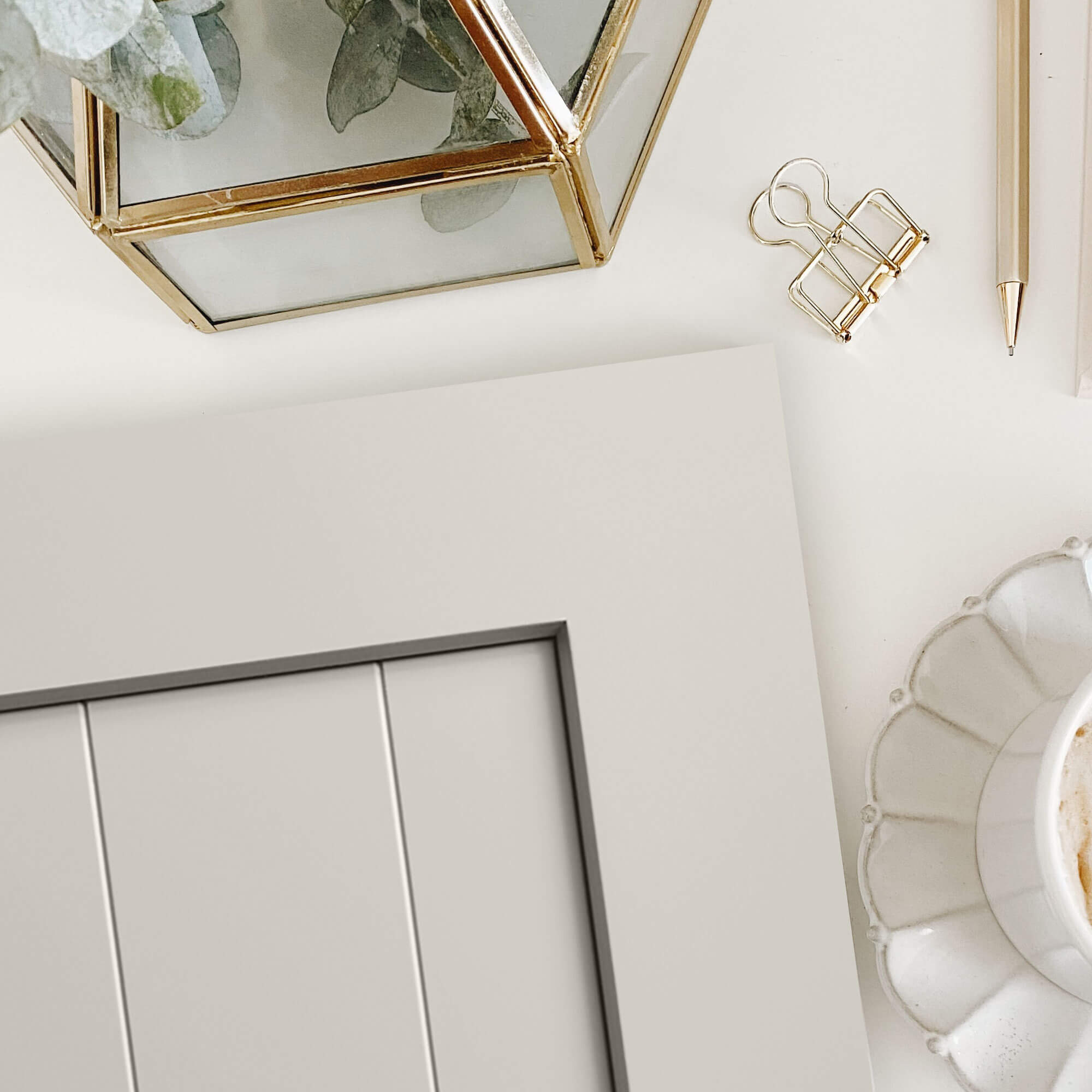 A flat panel cabinet door with a shiplap center panel and an off-white, taupe painted finish.