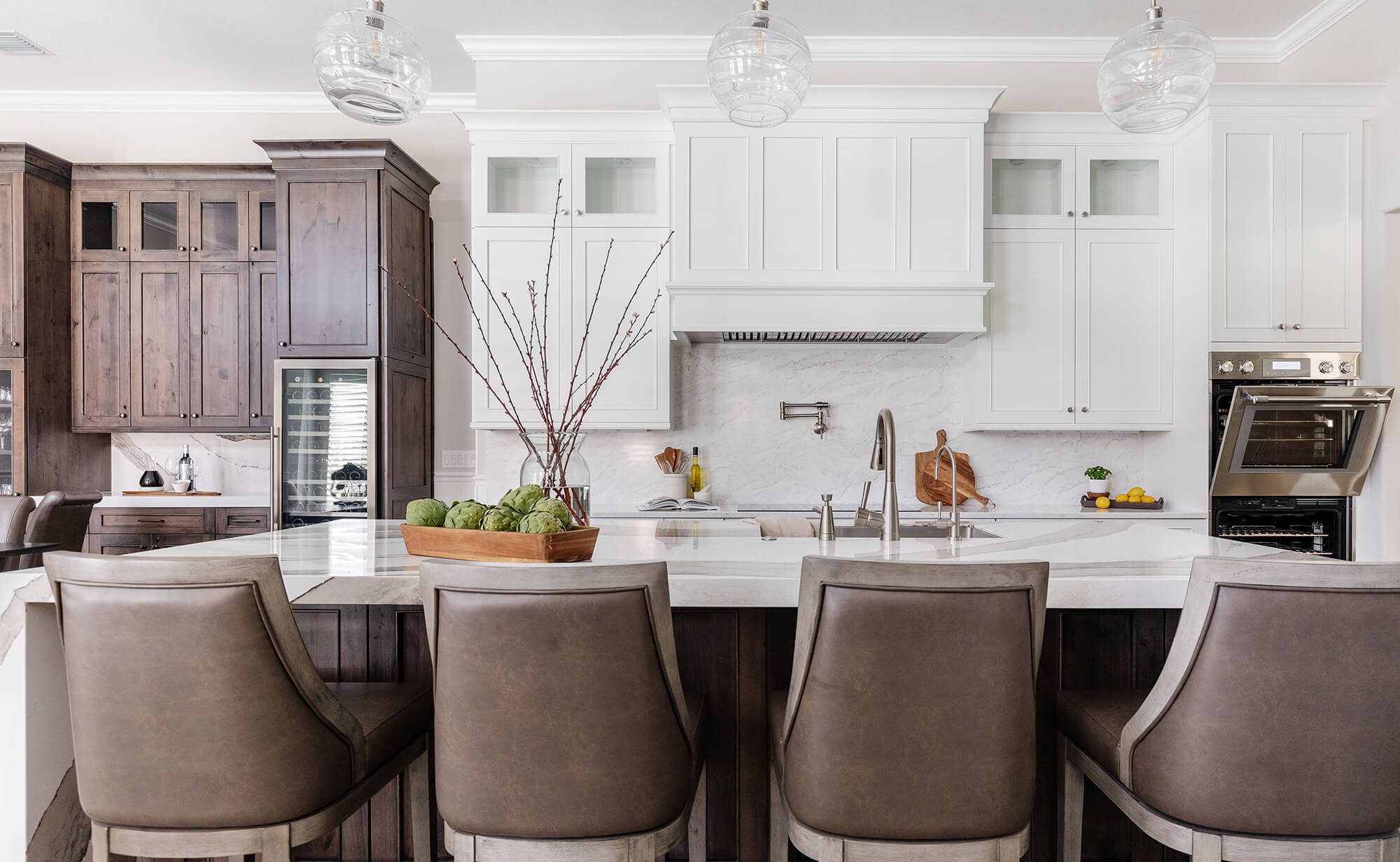 A beautiful kitchen with a warm color palette and bright white painted cabinets.