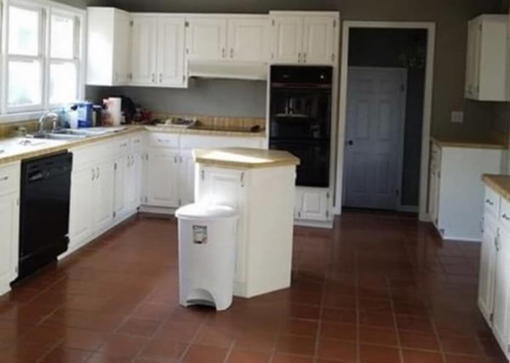 A large kitchen with a very tiny kitchen island that makes no sense.