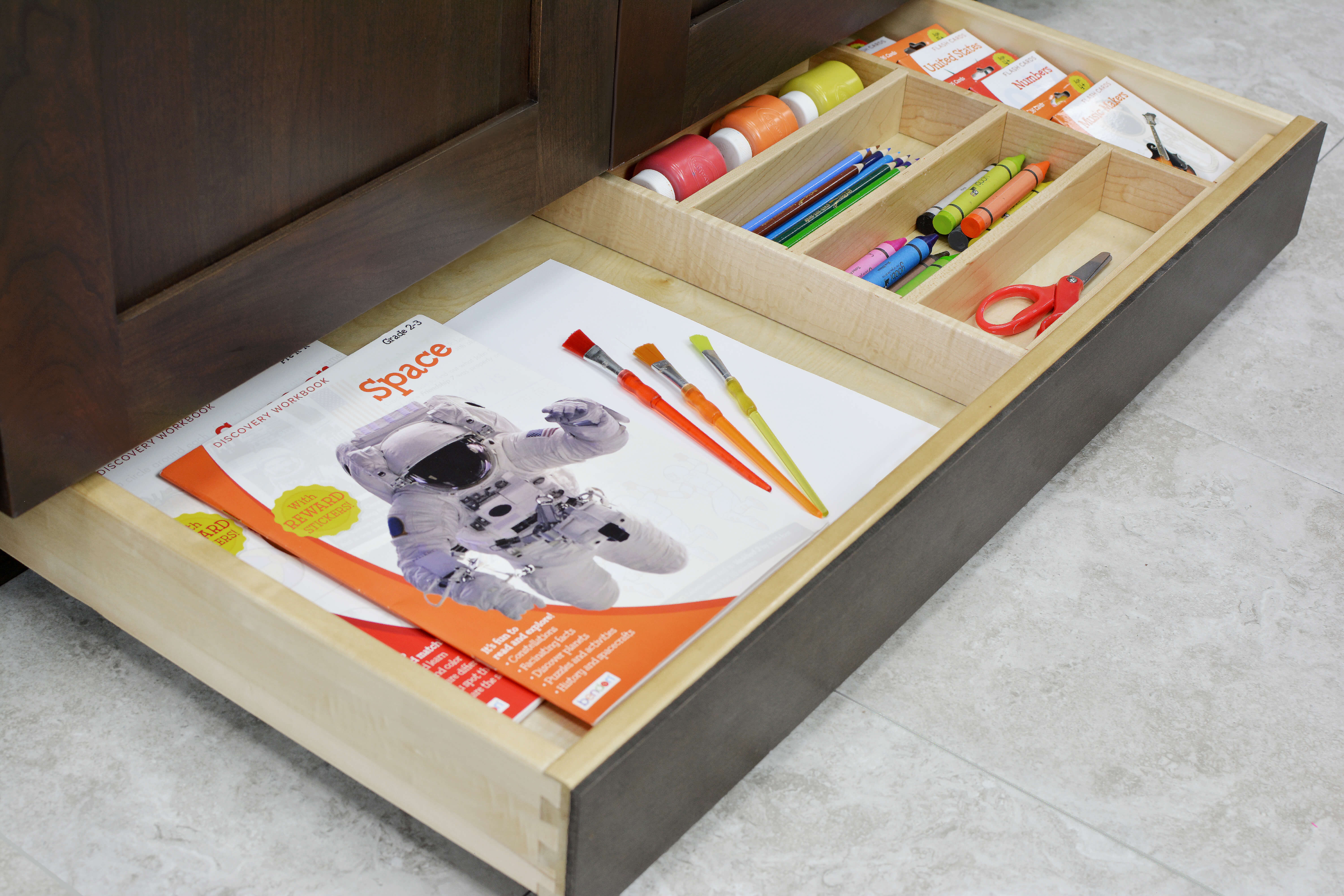 Miscellaneous items can find a home in a Dura Supreme Toe-Kick Drawer hidden at the foot of your cabinets.