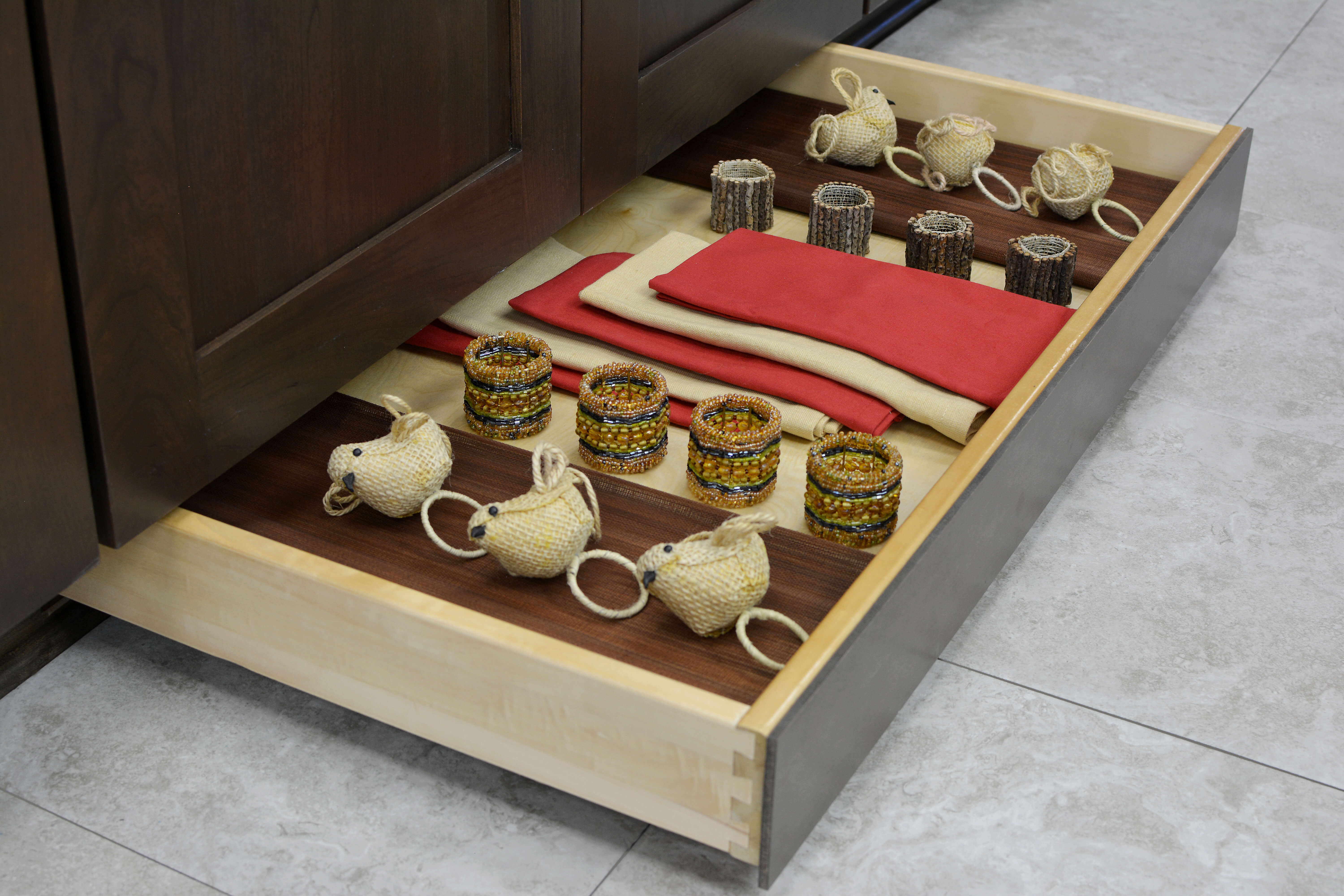 Miscellaneous items can find a home in a Dura Supreme Toe-Kick drawer hidden at the foot of your cabinets. It is the perfect place for stashing your seasonal table dressings, linens, candles, and more!