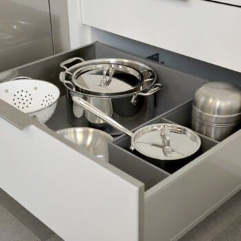 Modern kitchen cabinets featuring Deep Drawer Organizer for Stainless Steel Drawers With Pots and Pans by Dura Supreme Cabinetry.