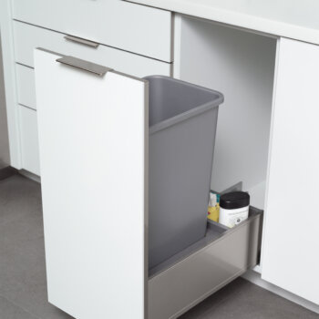 Base Recycling Center in Stainless Steel from Dura Supreme Cabinetry. An in-cabinet trash can in a pull-out stainless steel hardware creates a fantastic solution for keeping your kitchen waste and/or recycling tucked away, yet easy to access. Dura Supreme’s standard Touch Latch mechanism allows you to open this cabinet easily hands-free with the touch of a knee, when your hands are full or wet, to help keep your kitchen looking spick and span. For additional hands-free opening and closing assistance, an optional SERVO-DRIVE feature is available to electronically open and close this cabinet with the touch of a knee.