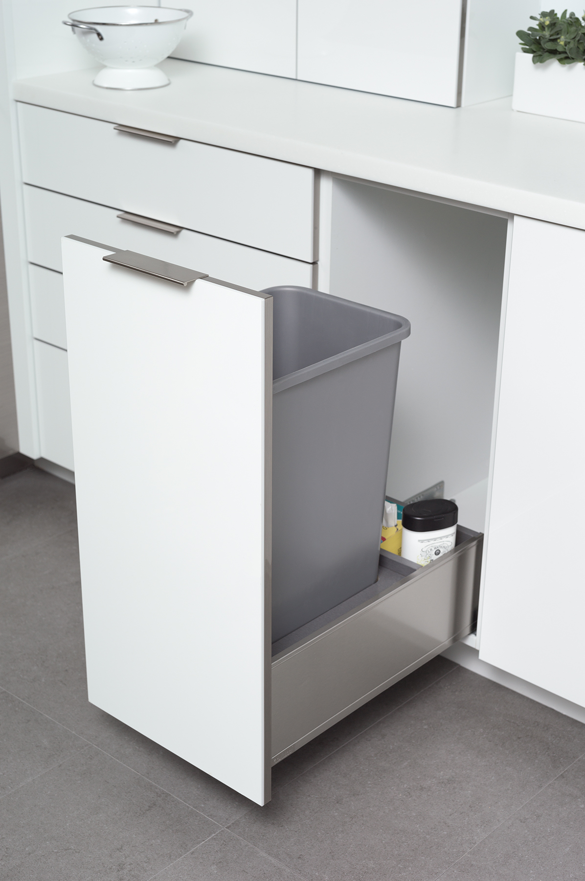 Base Recycling Center in Stainless Steel from Dura Supreme Cabinetry. An in-cabinet trash can in a pull-out stainless steel hardware creates a fantastic solution for keeping your kitchen waste and/or recycling tucked away, yet easy to access. Dura Supreme’s standard Touch Latch mechanism allows you to open this cabinet easily hands-free with the touch of a knee, when your hands are full or wet, to help keep your kitchen looking spick and span. For additional hands-free opening and closing assistance, an optional SERVO-DRIVE feature is available to electronically open and close this cabinet with the touch of a knee.