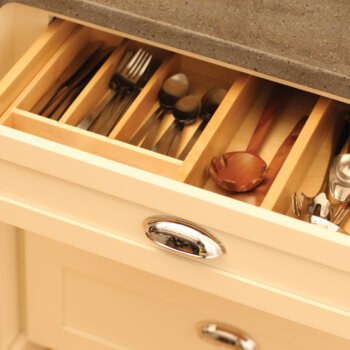 An organized kitchen drawer with dividers for silverware and kitchen utensils.