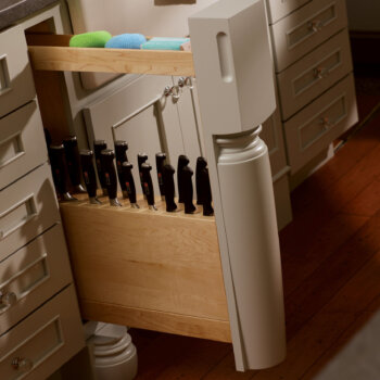 Dura Supreme Cabinetry's pull-out cabinet with a slotted Knife Block hidden behind a decorative turned post.