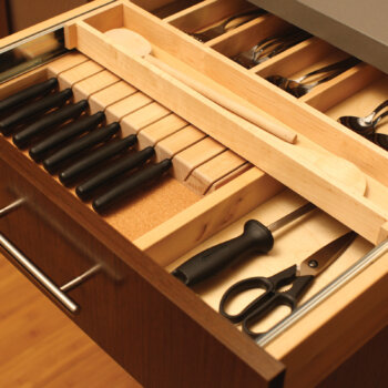 A two-tier slotted knife block tray and knife holder creates organized silverware and cutlery storage inside a kitchen cabinet drawer.