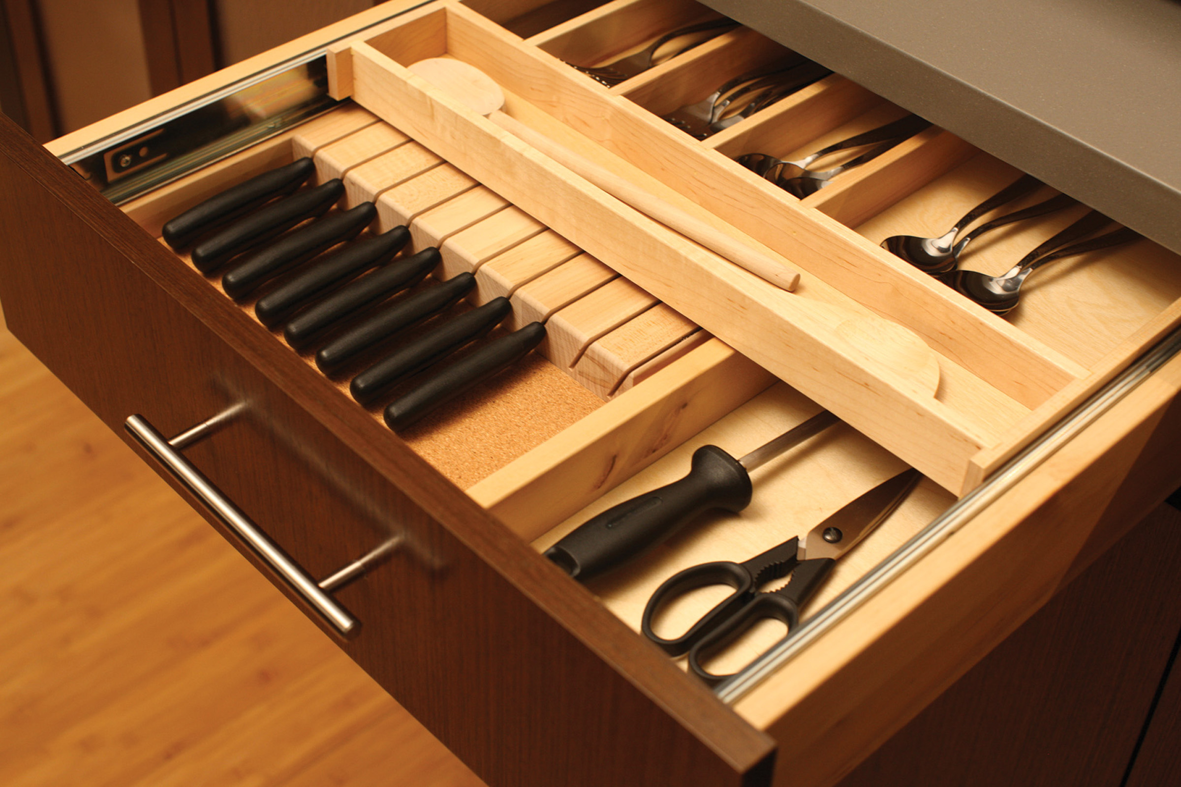 A two-tier slotted knife block tray and knife holder creates organized silverware and cutlery storage inside a kitchen cabinet drawer.