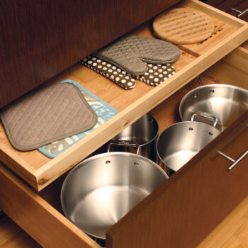 Conveniently store oven mitts and potholders in a Dura Supreme shallow roll-out above a pot and pant drawer (ROSAD).