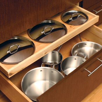 A Shallow Roll-Out Above Drawer neatly stores the lids for the pots and pans that are stored in the deep drawer below. Discover pot and pan storage solutions for kitchen cabinets with Dura Supreme.