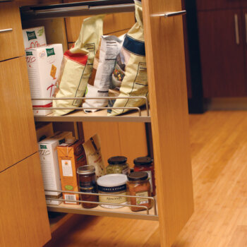 Dura Supreme base cabinet with a pull-out pantry accessory that creates neat storage of pantry goods within a narrow space.