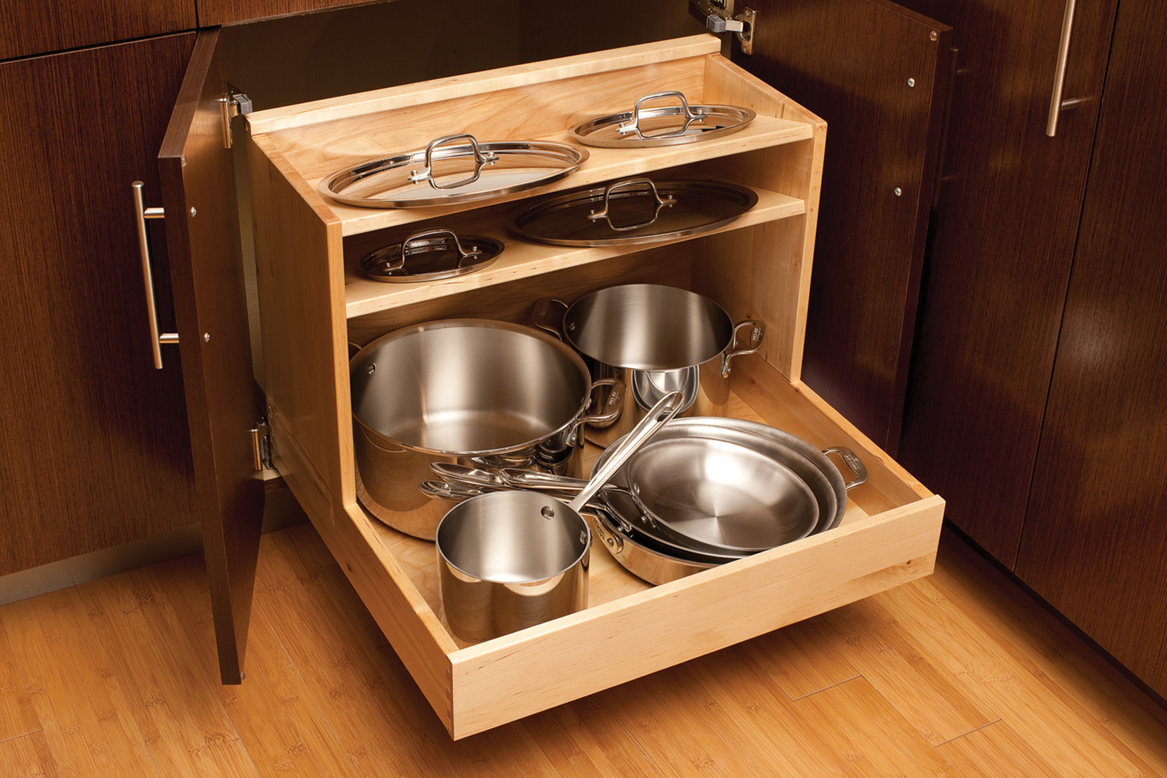 An entire cookware collection can be organized neatly in this single pull-out that houses pots and pans in the lower section and organizes lids above.