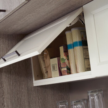 A wall cabinet with a stay-lift cabinet door with hinge-top mechanism that helps lift upwards but also protect from the cabinet door slamming down.