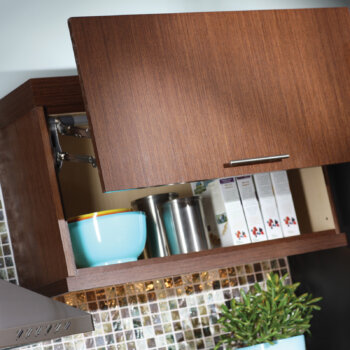 If space allows above the cabinet, a lift-door (WLD) provides full-access to upper cabinets that are hard to reach. Kitchen storage idea from Dura Supreme Cabinetry.