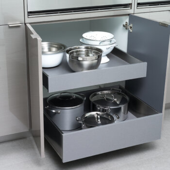 A set of modern stainless steel roll-out shelves in a contemporary styled base cabinet from Dura Supreme.