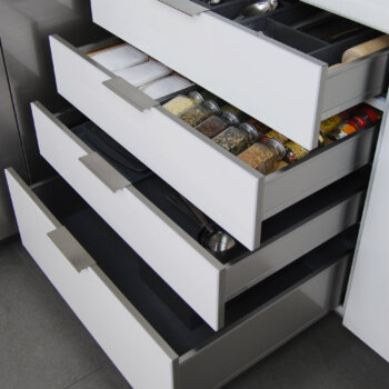 Bria Frameless Cabinetry from Dura Supreme with a stack of modern stainless steel drawers.
