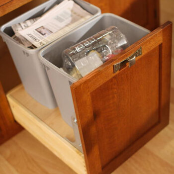 A base cabinet with a recycling center and drawer above for trash and recycling bins with a hands-free touch latch feature.