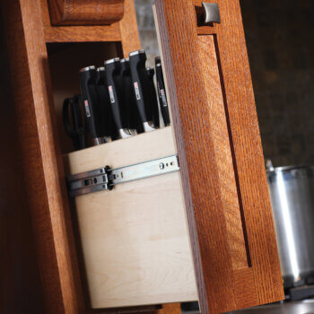 A pull-out cabinet hidden in the wood hood towers is designed to organize a full collection of cutlery in a knife block.