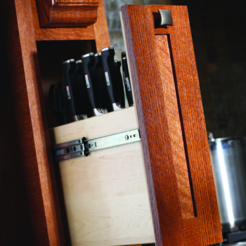 A pull-out cabinet hidden in the wood hood towers is designed to organize a full collection of cutlery in a knife block.