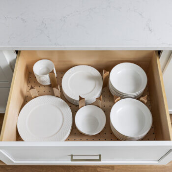 A Dish Storage Drawer conveniently stores stacks of plates and bowls in the kitchen.